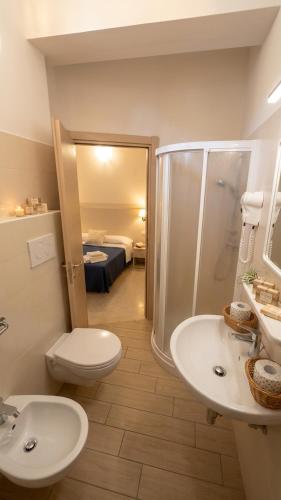 a bathroom with a shower and a toilet and a sink at B&B - Meuble' - Hotel " CORDIALE " in Misano Adriatico