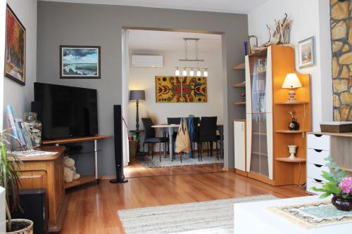a living room with a television and a dining room at Sunny Day Apartment in Pomorie