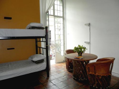 a room with two bunk beds and a table at Hostel Hospedarte Centro in Guadalajara