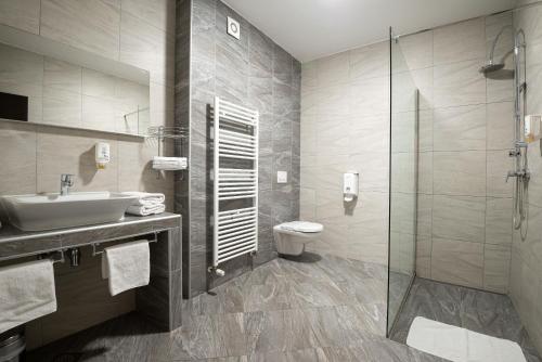 a bathroom with a sink and a toilet and a shower at B&B Villa Angy in Korenica