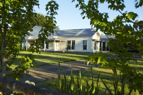 uma casa branca com uma cerca à frente. em Grampians View B&B em Dunkeld