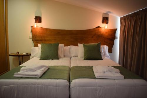 a bedroom with a large bed with green and white pillows at Alojamento Madeira`s in Videmonte