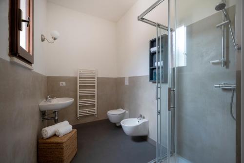 a bathroom with a toilet and a sink and a shower at Oltre i coni in Santa Lucia