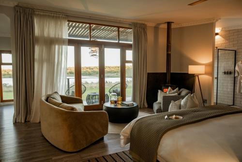a bedroom with a bed and a living room at Cheetah Ridge Lodge in Nambiti Game Reserve