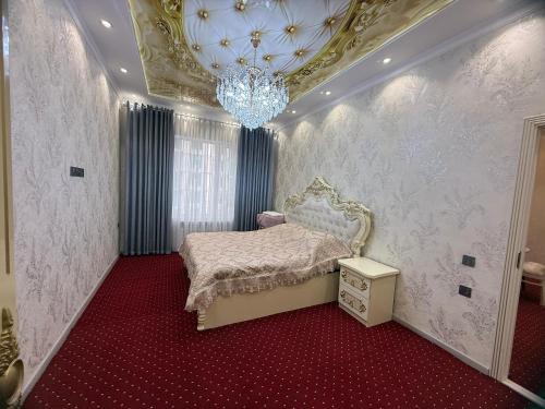 a bedroom with a bed and a chandelier at Khudzhand City in Khujand