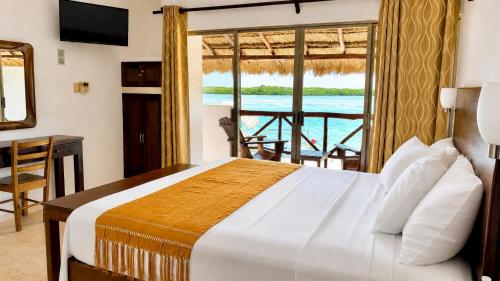 a bedroom with a bed and a view of the water at Hotel Villa de Pescadores in Río Lagartos