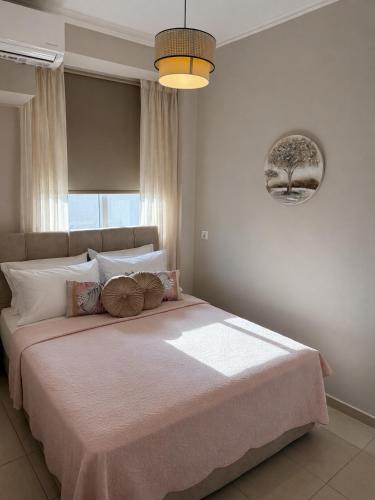 a bedroom with a large bed with a pink blanket at Marinas view apartment in Limenas