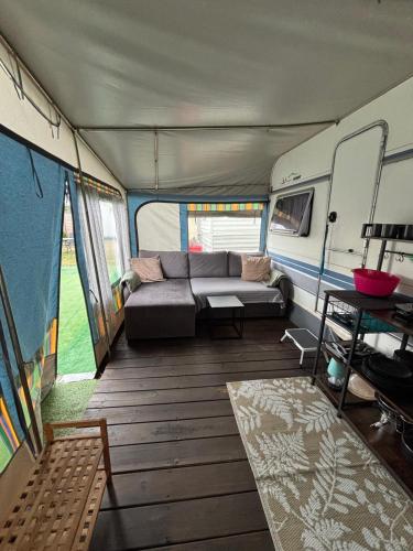 a living room with a couch inside of an rv at AMOMEA CAMP in Jastarnia