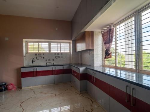 a kitchen with red and white cabinets and windows at SVL HomeStay in Chik Ballāpur