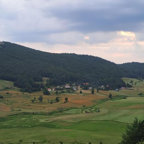 a view of a golf course with mountains in the background at Suvi Vrh mountain cabin in Gacko