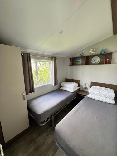 a small room with two beds and a window at Prachtig chalet DE WADLOPER in Westerland