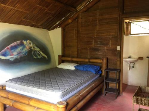 a bedroom with a bed with a painting on the wall at Renacer de Gaia 888 in Mompiche