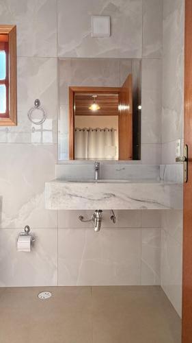 a bathroom with a sink and a mirror at Chalés Nascer do Sol in Camanducaia