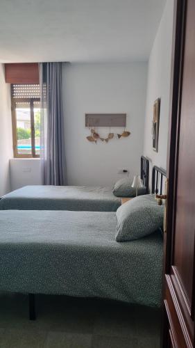 two beds sitting in a room with a window at Dorna Vella in Valdoviño