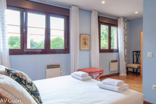 a bedroom with a bed with two towels on it at La Xana de Peón AVG in Candanal