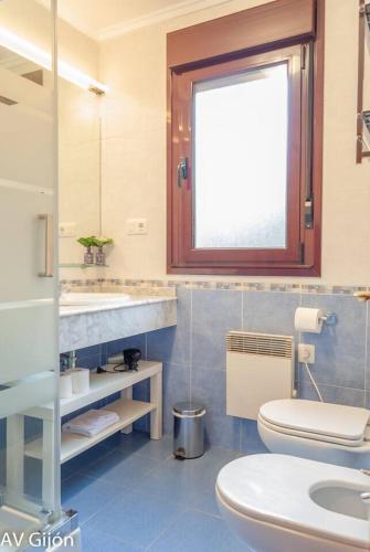a bathroom with a toilet and a sink and a window at La Xana de Peón AVG in Candanal