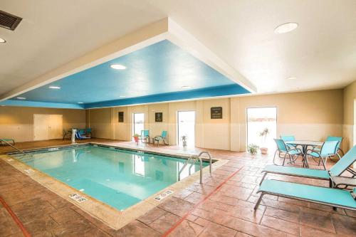 道奇市的住宿－康福特套房酒店- 道奇城，一个带桌椅的大型室内游泳池