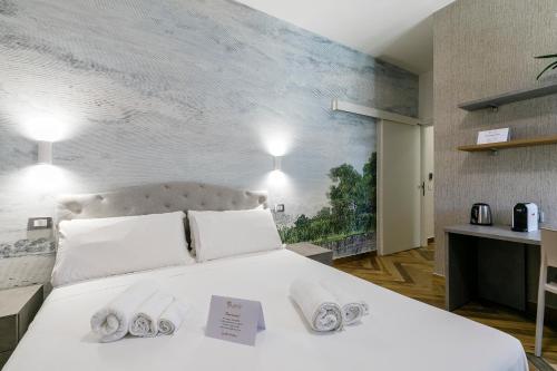 a bedroom with a large white bed with towels on it at LAROS Dimora Dorica in Ancona