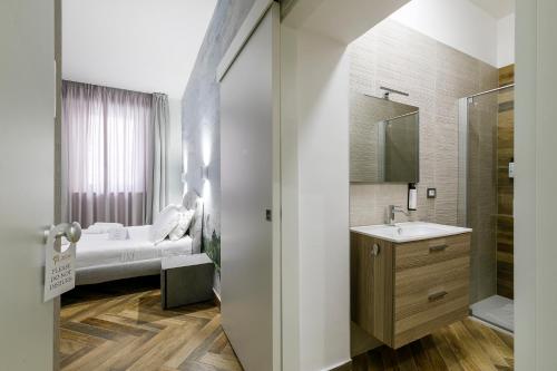 a bathroom with a bed and a sink and a mirror at LAROS Dimora Dorica in Ancona