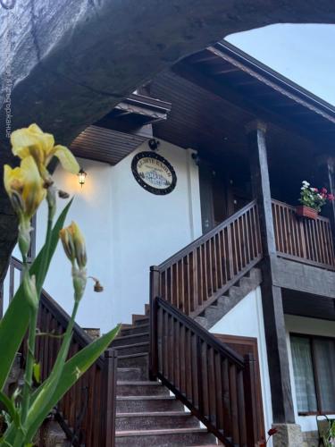 a house with stairs and a clock on the wall at Белите Къщи in Seltse