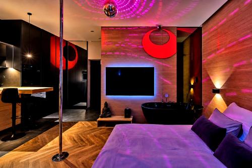 a bedroom with a bed and a tub and a tv at LupoApartments z Klimatyzacją do wyboru z Jacuzzi Pole Dance Parking Dostęp na Kod in Łódź