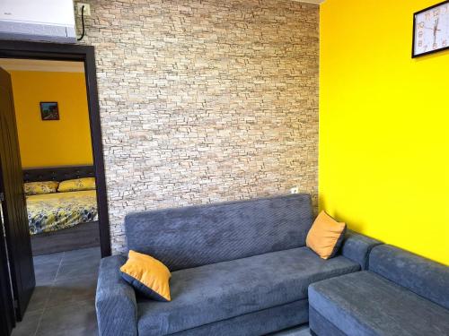 a blue couch in a room with a brick wall at CityHaven in Ureki