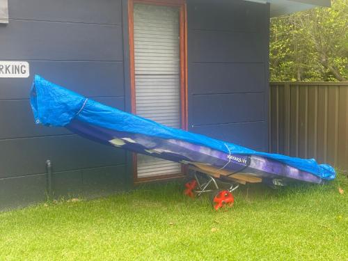 a blue kayak sitting on the side of a house at Lake House Escape - Lake Front Couples Retreat! in Morisset East