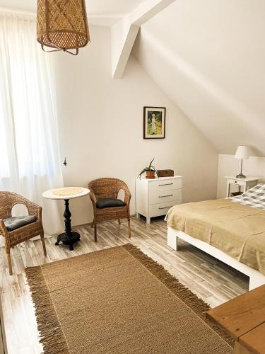a bedroom with a bed and a table and chairs at Biały Dom in Kąty Rybackie