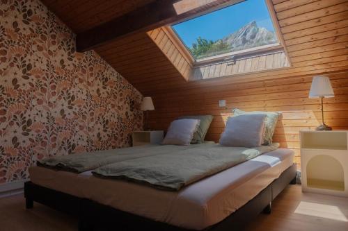 a bedroom with a large bed with a window at La VilLaye in Laye