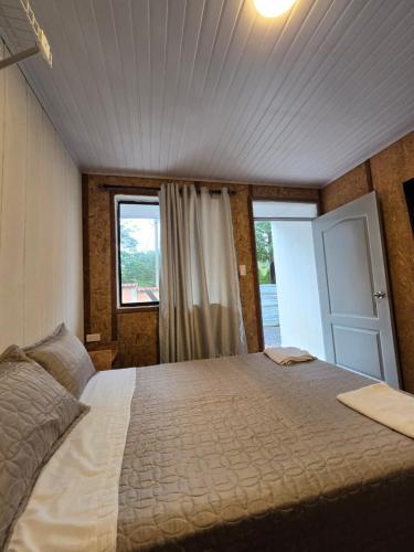 a bedroom with a large bed and a window at EcoHotel Farallones in San Pedro de Jagua