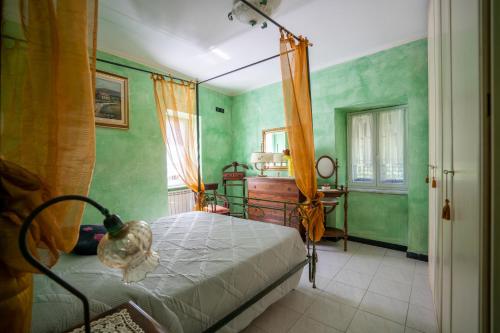 a bedroom with a canopy bed and green walls at Villetta Dina in Scoffera