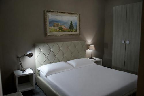 a bedroom with a white bed and a picture on the wall at KAIROS - Centro di Oliveto Citra in Oliveto Citra