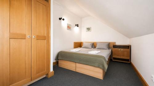 a small bedroom with a bed and a closet at Rennerka Horská bouda in Strážné
