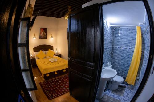 a small bedroom with a bed and a sink at Riad Al Fanouss in Fez