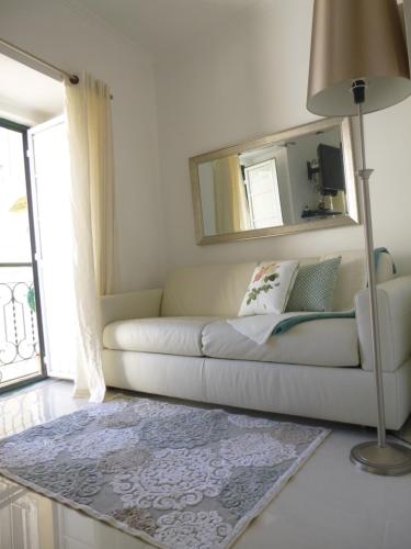 sala de estar con sofá blanco y espejo en Lovehome Apartment, en Lisboa
