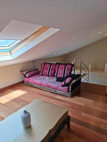 a living room with a couch with pink pillows at Casita relax Amariz Loureiro in Oya