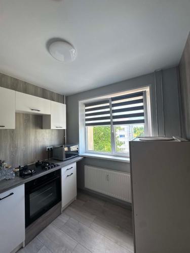 a kitchen with white cabinets and a window at 3 apartamentai in Naujoji Akmenė