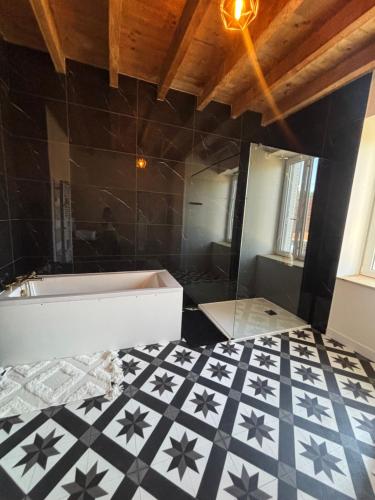 a bathroom with a tub and a tiled floor at Gîte de Fumouse in Le Mayet-de-Montagne