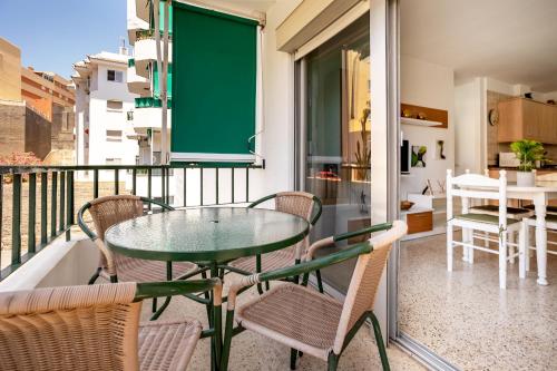 a balcony with a glass table and chairs on a balcony at Home2Book Sunny Terrace Apt, el Rincón de ManFe in Candelaria