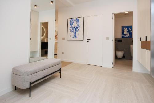 a living room with a bench and a room with white walls at Villa Marcello in Zadar