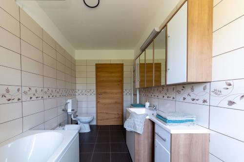 a bathroom with a tub and a toilet and a sink at Apartma Luketovi in Vojščica