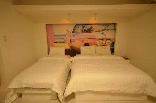 two beds in a room with a car on the wall at Jeonju Cherevill Motel in Jeonju