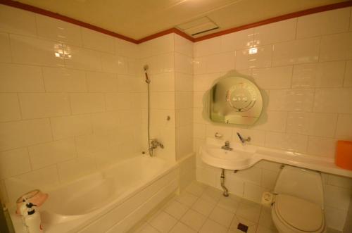 a bathroom with a tub and a toilet and a sink at Jeonju Cherevill Motel in Jeonju