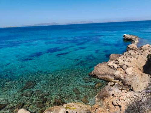 a large body of water with rocks and blue water at Antigone Salty Studio in Vathí