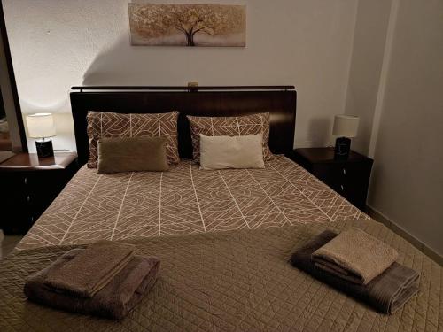 a bedroom with a large bed with two towels on it at Sweet Home Nea Roda! in Nea Roda