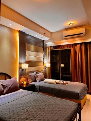 a hotel room with two beds and a television at Shell Residences Tower A B in Manila