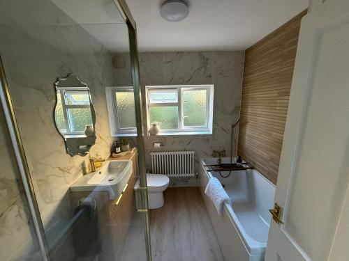 a bathroom with a sink and a toilet and a shower at Penderels, Willersey in Broadway