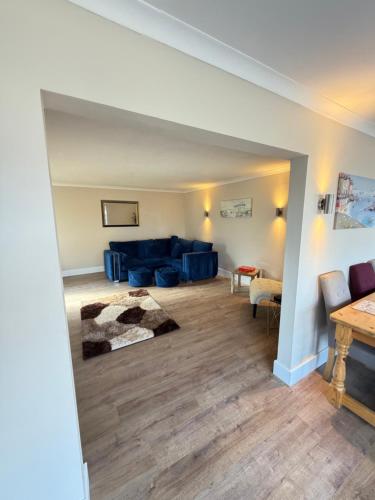 a living room with a blue couch and a table at Channel side in Pevensey