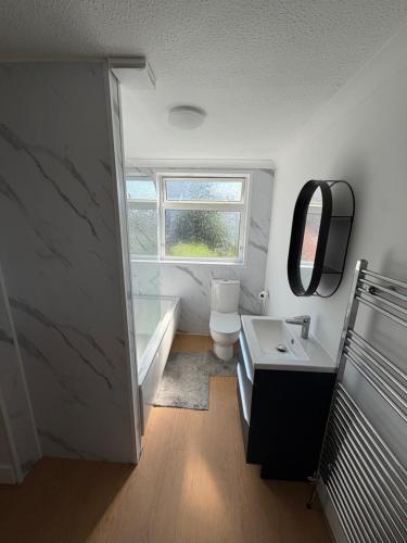 a bathroom with a sink and a toilet and a window at Channel side in Pevensey