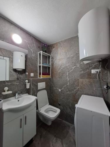 a bathroom with a white toilet and a sink at Villa Kotor Air in Muo